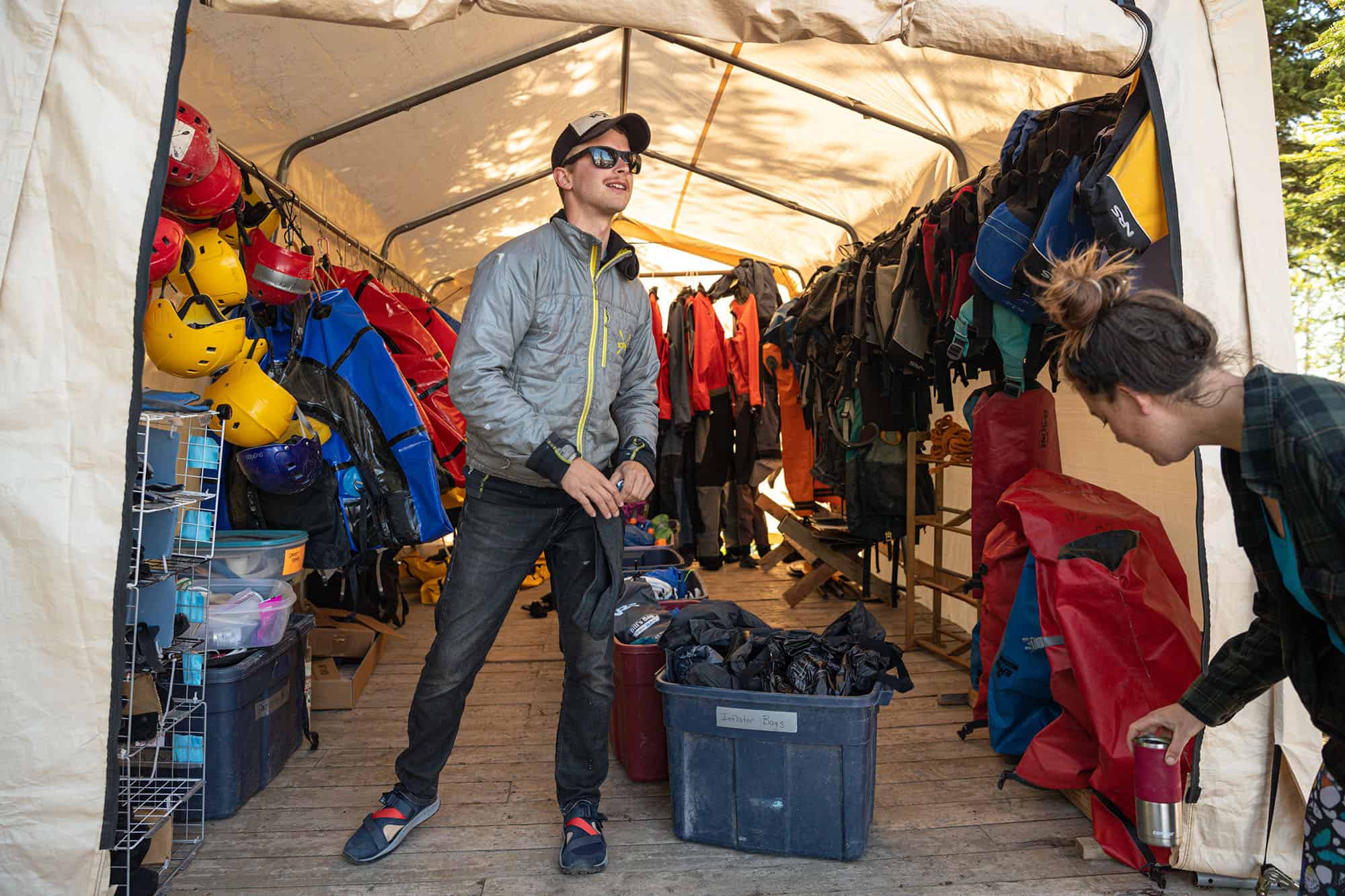 a person in front of the packrafting gear tent
